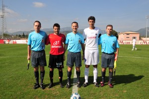 El trío arbitral con los capitanes del partido