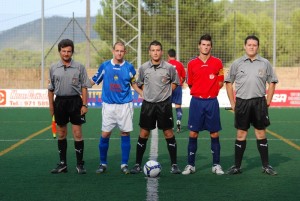 El trío arbitral con los capitanes del partido