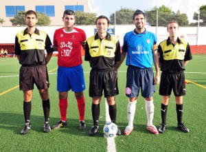 El trio arbitral con los capitanes del partido