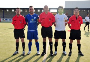 El trio arbitral con los capitanes del partido