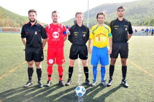 El trío arbitral con los capitanes del partido