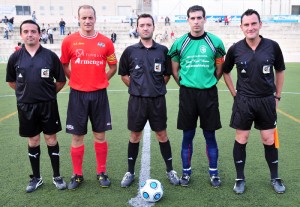 El trío arbitral con los capitanes del partido