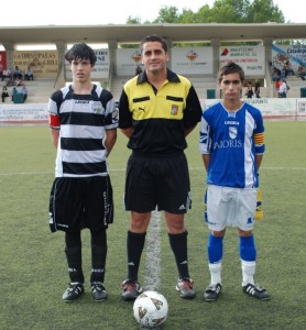 El colegiado con los capitanes del partido