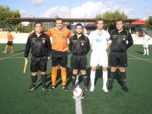 El trío arbitral con los capitanes del partido