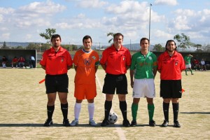 El trío arbitral con los capitanes del partido