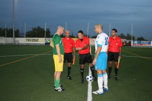 El trío arbitral con los capitanes del partido