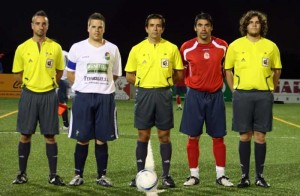 El trío arbitral con los capitanes del partido