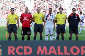 El trio arbitral con los capitanes del partido