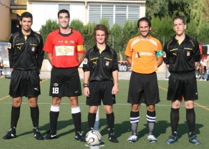 El trío arbitral con los capitanes del partido