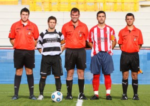 El trio arbitral con los capitanes del partido