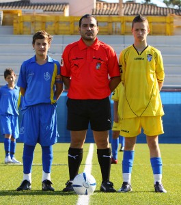 El colegiado con los capitanes del partido