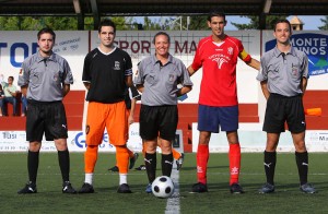 El trío arbitral con los capitanes del partido