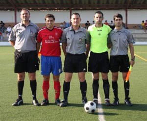 El trio arbitral con los capitanes del partido