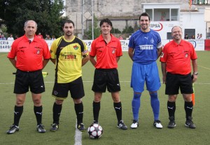 El trío arbitral con los capitanes del partido