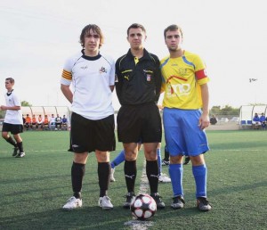 El colegiado con los capitanes del partido