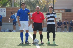 El colegiado con los capitanes del partido