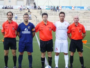 El trio arbitral con los capitanes del partido