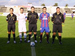 El trío arbitral con los capitanes del partido