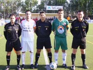 El trio arbitral con los capitanes del partido