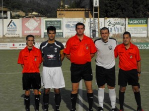 El trío arbitral con los capitanes del partido