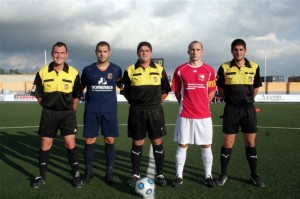 El trío arbitral con los capitanes del partido