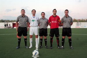 El trio arbitral con los capitanes del partido