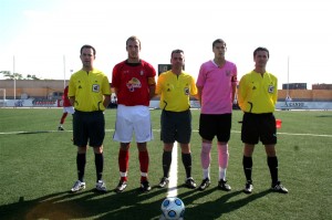 El trio arbitral con los capitanes del partido