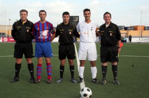 El trío arbitral con los capitanes del partido