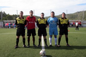 El trio arbitral con los capitanes del partido