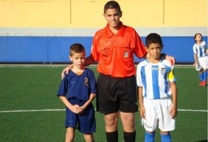 El colegiado con los capitanes del partido