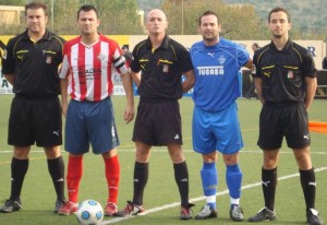 El trío arbitral con los capitanes del partido