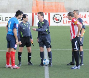 El trio arbitral con los capitanes del partido