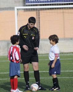 El colegiado con los capitanes del partido