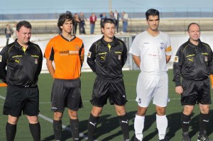 El trío arbitral con los capitanes del partido