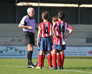 El colegiado con los capitanes del partido