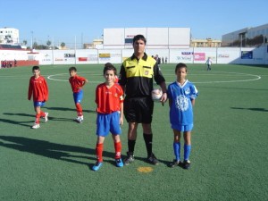 El colegiado con los capitanes del partido