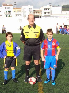 El colegiado con los capitanes del partido