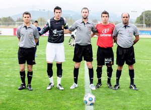 El trío arbitral con los capitanes del partido