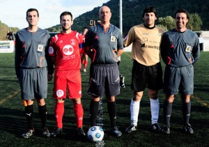 El trío arbitral con los capitanes del partido