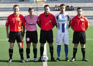 El trío arbitral con los capitanes del partido