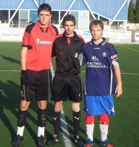 El colegiado con los capitanes del partido