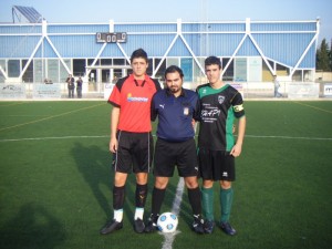 El colegiado con los capitanes del partido