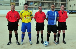 El trio arbitral con los capitanes del partido