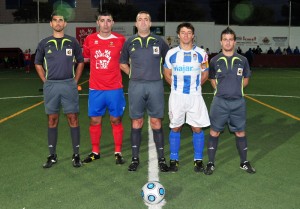 El trío arbitral con los capitanes del partido