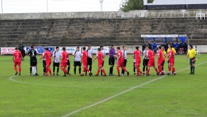 Los jugadores se saludan en el centro del campo