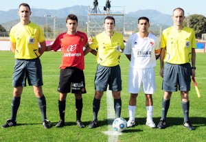 El trío arbitral con los capitanes del partido