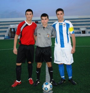 El colegiado con los capitanes del partido