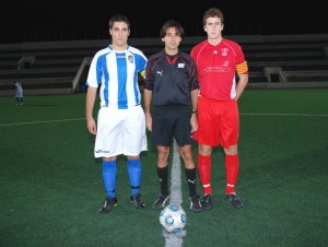 El colegiado con los capitanes del partido