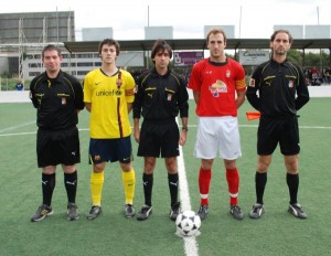 El trío arbitral con los capitanes del partido