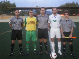 El trío arbitral con los capitanes del partido